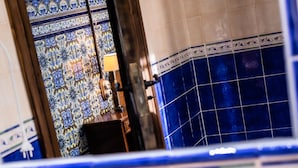 A bathroom with a sink, blue-tiled walls, and a decorative mirror. - Posada Real Quinta San José (Piedralaves)