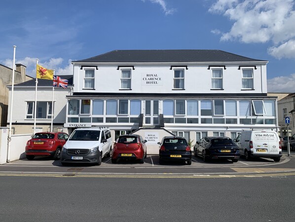 Un hotel con un cartel que dice "Royal Clarence Hotel" y varias banderas, incluyendo la bandera del Reino Unido.