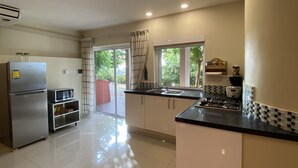 A modern kitchen with a refrigerator, microwave, and gas stove. - O Casarao Guesthouse (Willemstad)