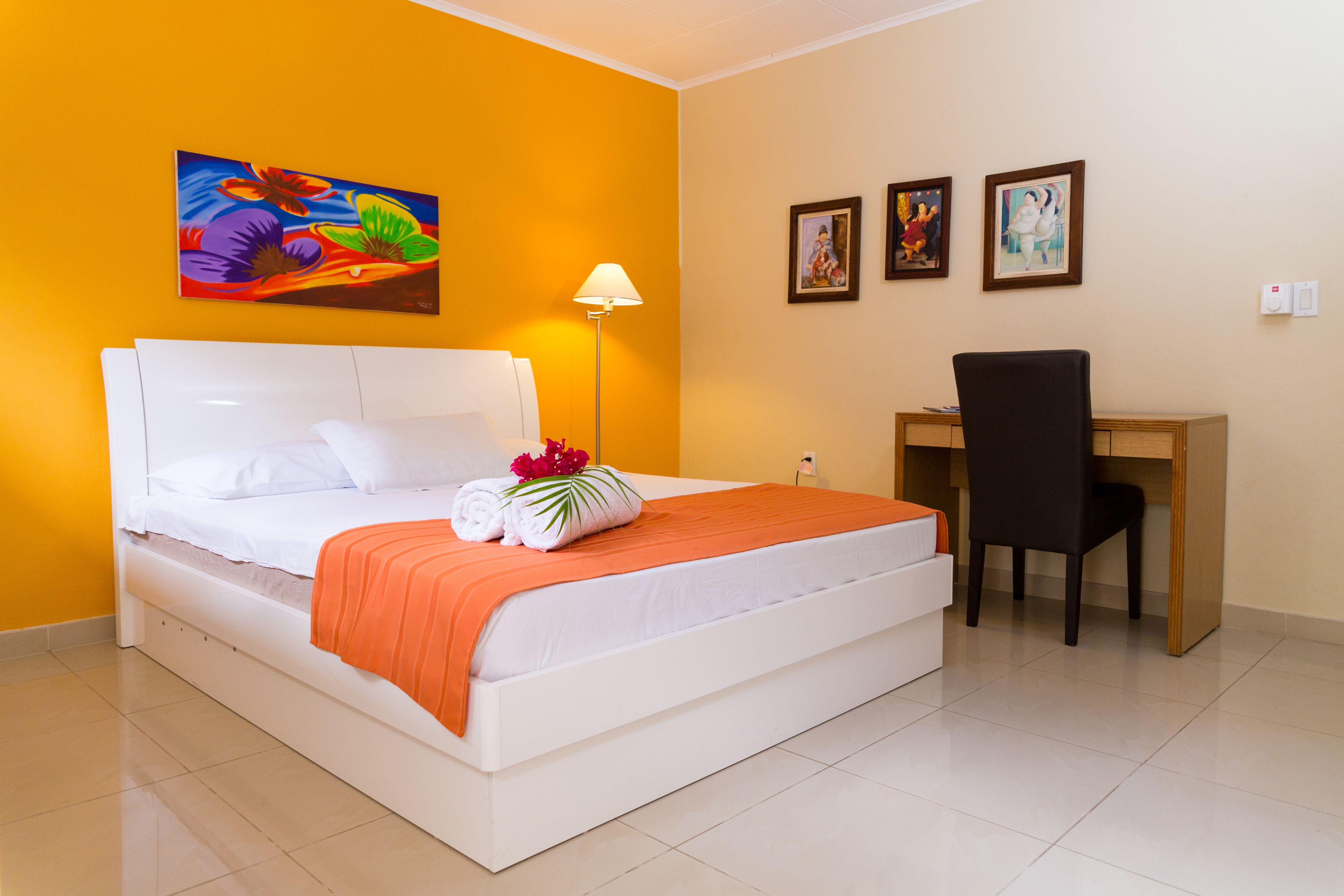 A hotel room with a bed, a desk, and a chair.