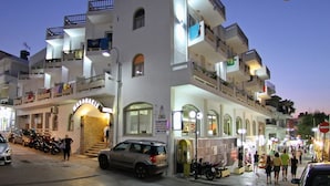 A multi-story hotel with balconies, a ground floor entrance, and a visible sign for a nearby laundry service. - Maragakis Beach Hotel (Hersonissos)