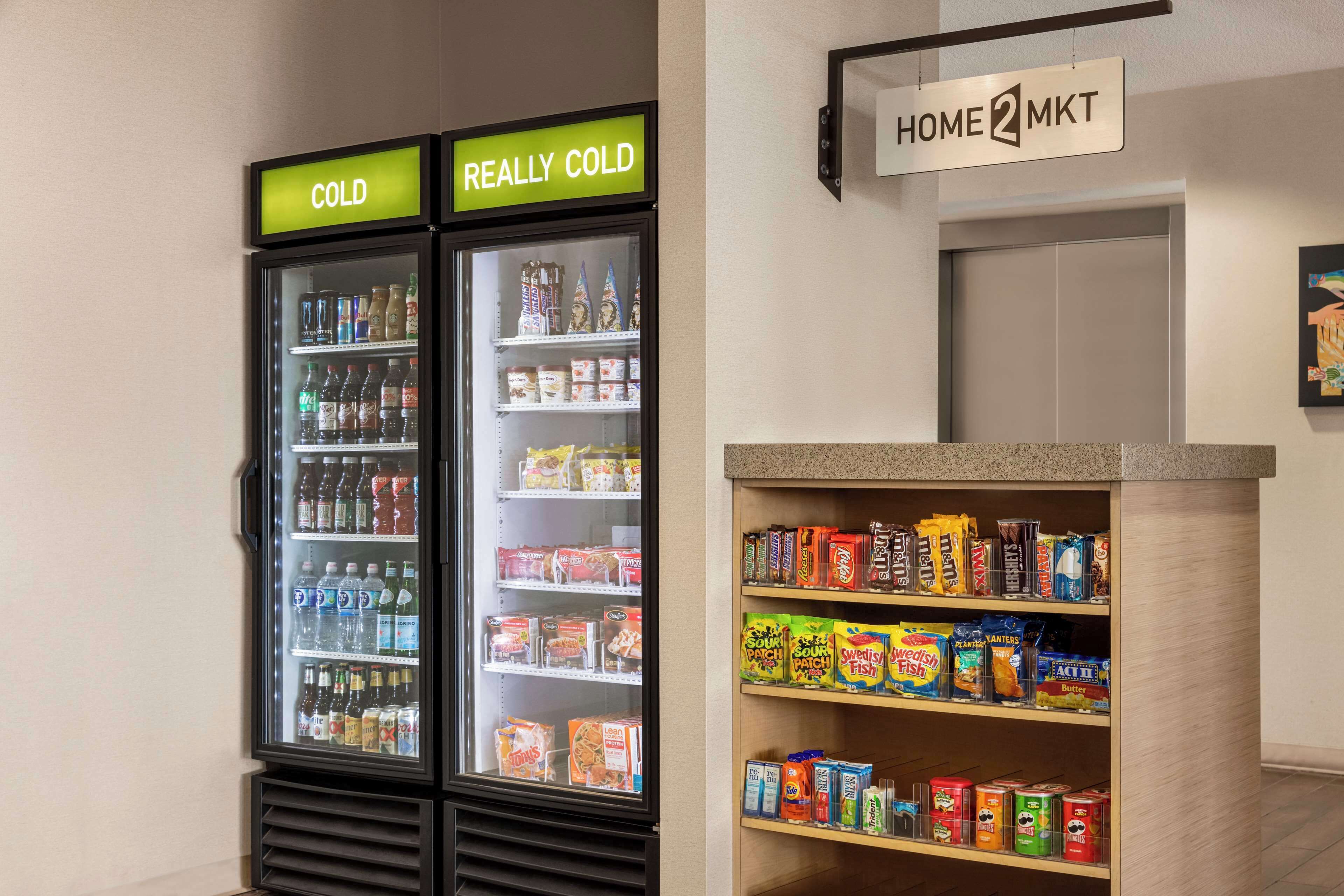 Two refrigerated beverage dispensers labeled "COLD" and "REALLY COLD," and a shelf stocked with snacks and beverages.