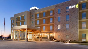 A multi-story hotel with a modern design, featuring a covered entrance and a sign indicating it is a Hilton property. - Home2 Suites by Hilton Lubbock (Lubbock)