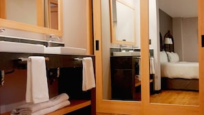 Un baño de hotel con dos lavamanos, un espejo y suelo de madera.