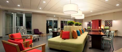 A modern lobby with seating areas, a reception desk, and a large window.