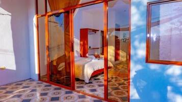 A room with a bed, a window, and a patterned floor.