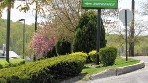 A green sign for Value Inn with an arrow pointing left for the entrance. - Value Inn Harrisburg - York (Etters)