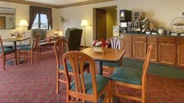A hotel room with a dining area, a kitchenette, and a large mirror. - Value Inn Harrisburg - York (Etters)