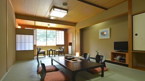 Een traditionele Japanse kamer met tatami vloerbedekking, een lage tafel en schuifdeuren.