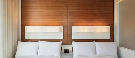 A hotel room with two beds, wooden paneling on the walls, and bedside lamps.