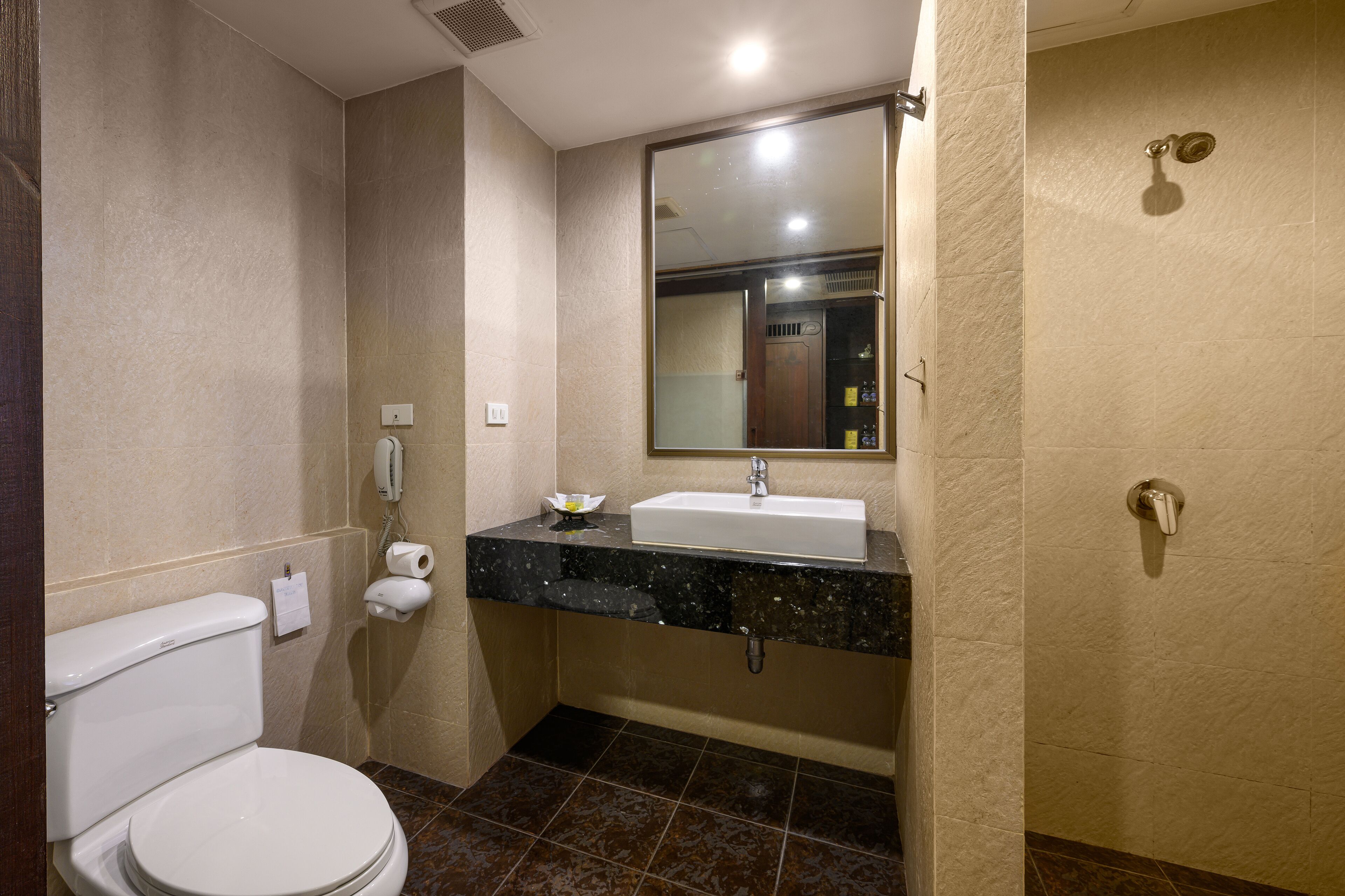 A bathroom with a toilet, sink, and shower.