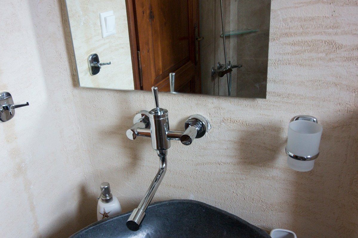 Un baño con lavamanos, espejo y ducha.