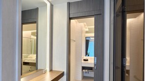 A modern bathroom with a wooden vanity, a round stool, and a glass shower enclosure. - The Regent Phuket Bangtao Beach (Choeng Thale)