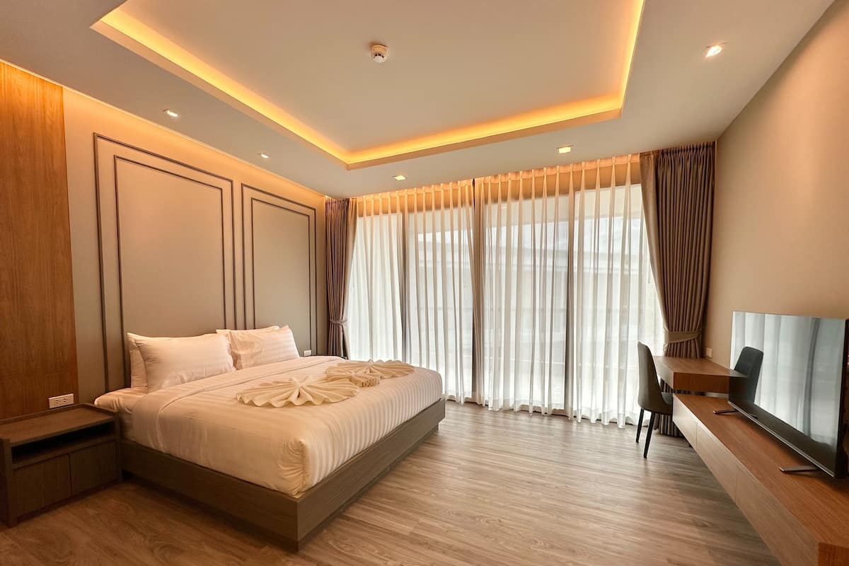 Une chambre d’hôtel moderne équipée d’un grand lit, d’un bureau avec une chaise et d’un téléviseur.