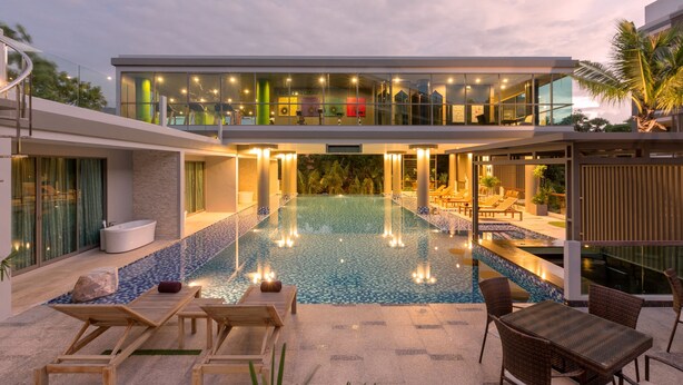 Ein modernes Hotel mit Dachpool, Liegestühlen und einem Essbereich.