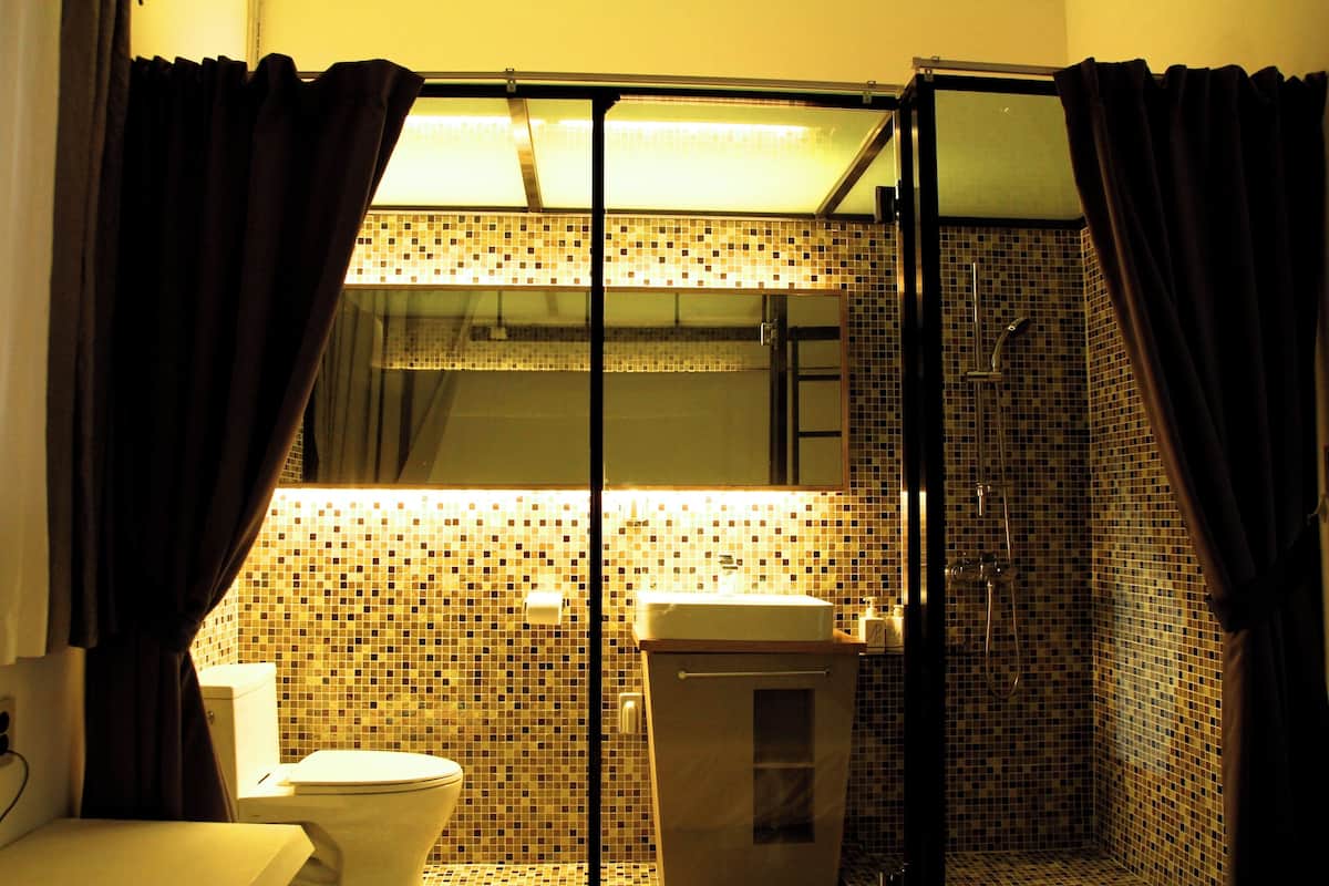 A bathroom with a toilet, sink, and shower.