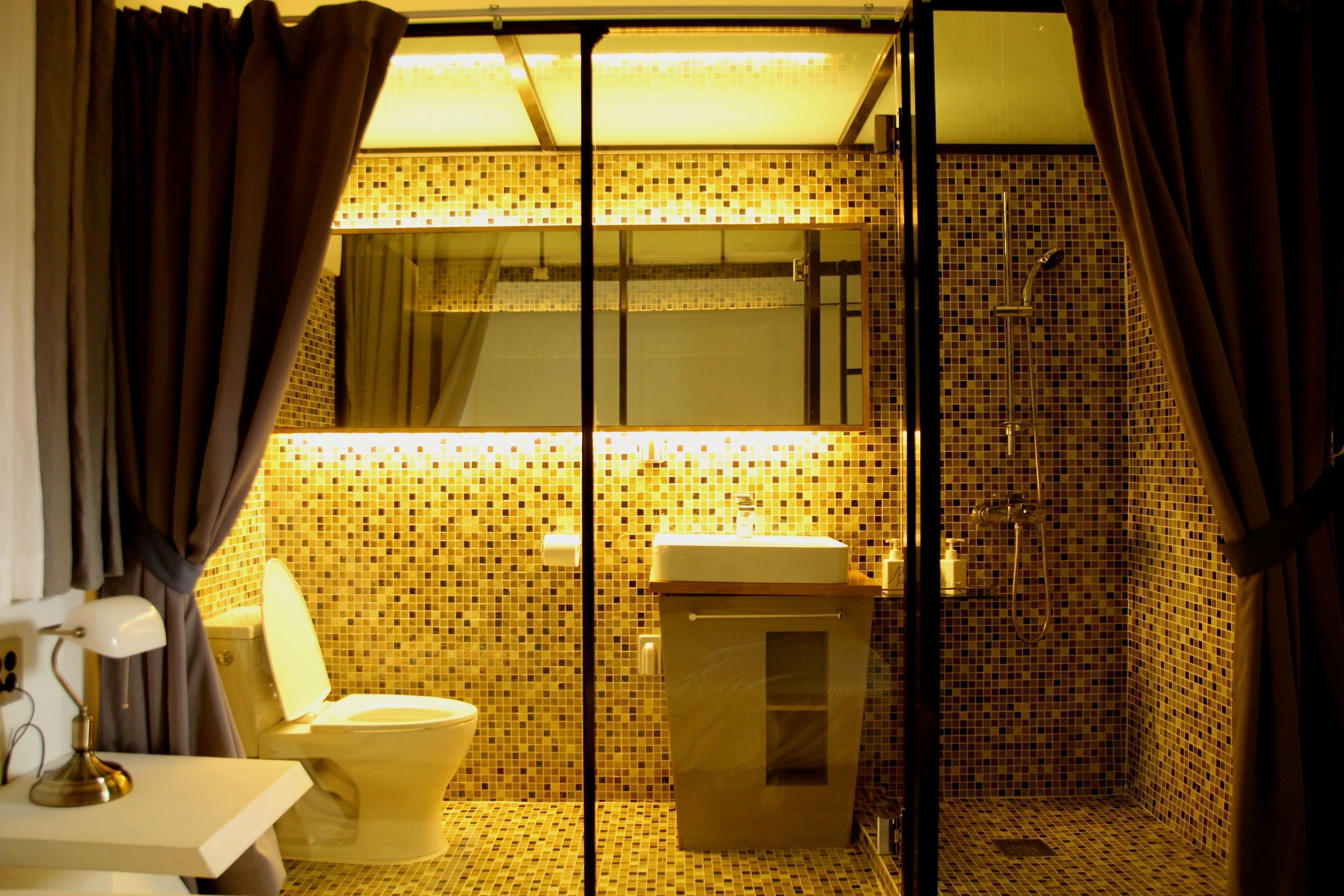 Une salle de bain avec des toilettes, un lavabo et une douche.