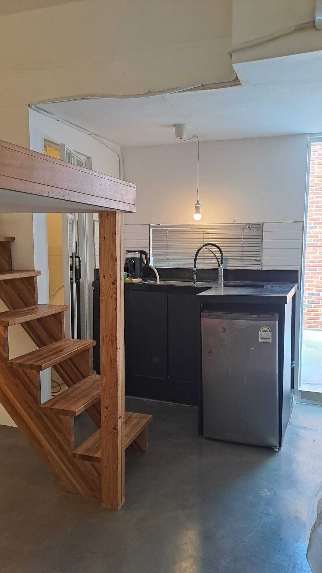 A kitchen with a built-in island, a sink, and a refrigerator.