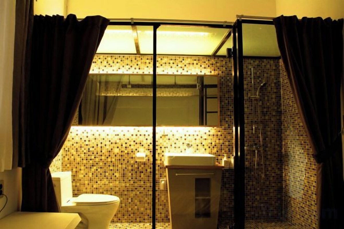 Une salle de bain avec douche, toilettes et lavabo.