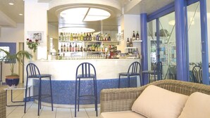 Een bar met een toonbank, drie stoelen en een rieten bank.