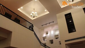 Un interior de varios niveles con una escalera, iluminación empotrada y elementos decorativos en las paredes.
