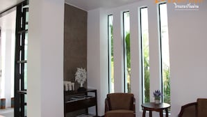Un interior moderno con una estantería, una silla y ventanas amplias.