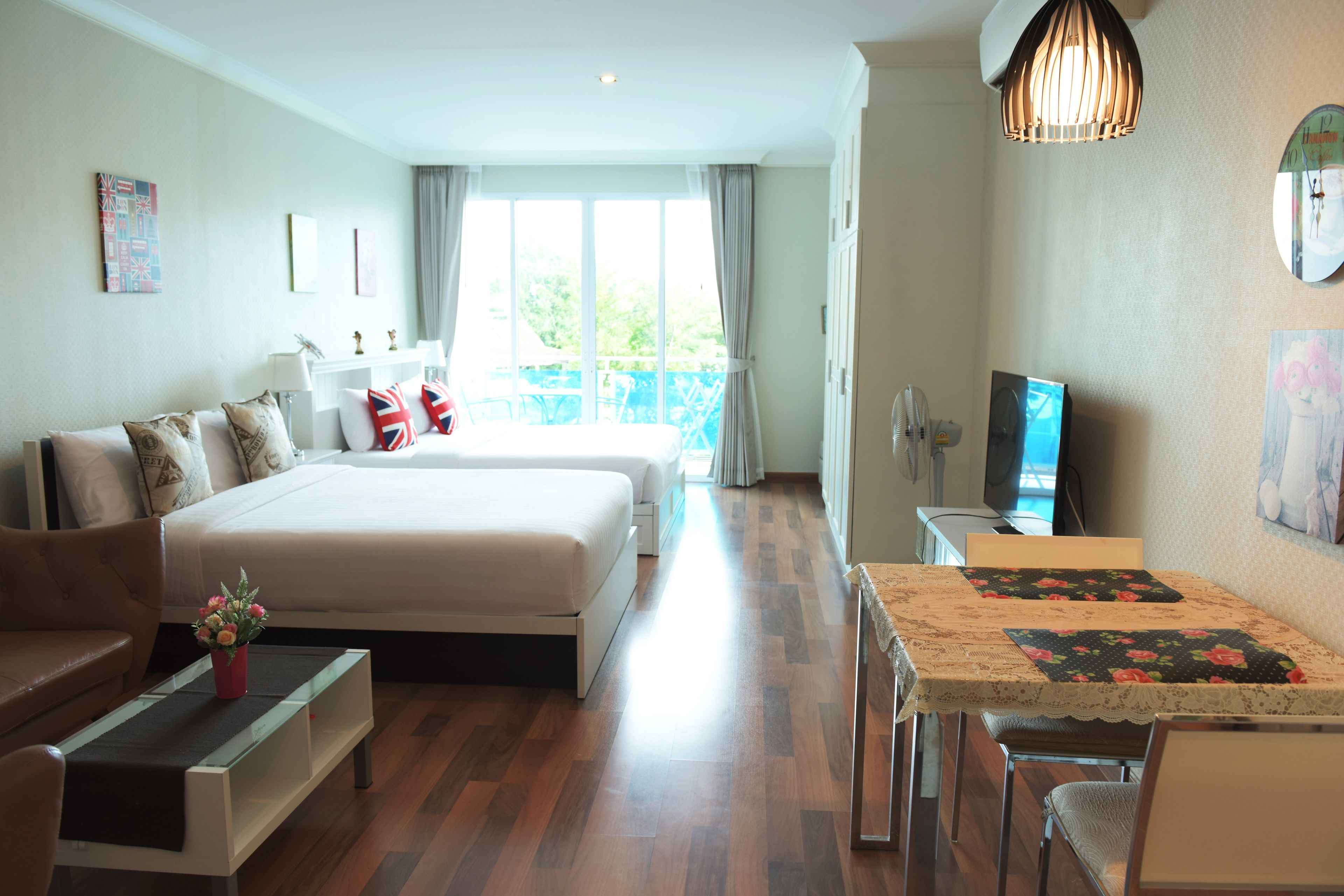 Una habitación de hotel con cama, sofá, mesa de comedor y televisión.