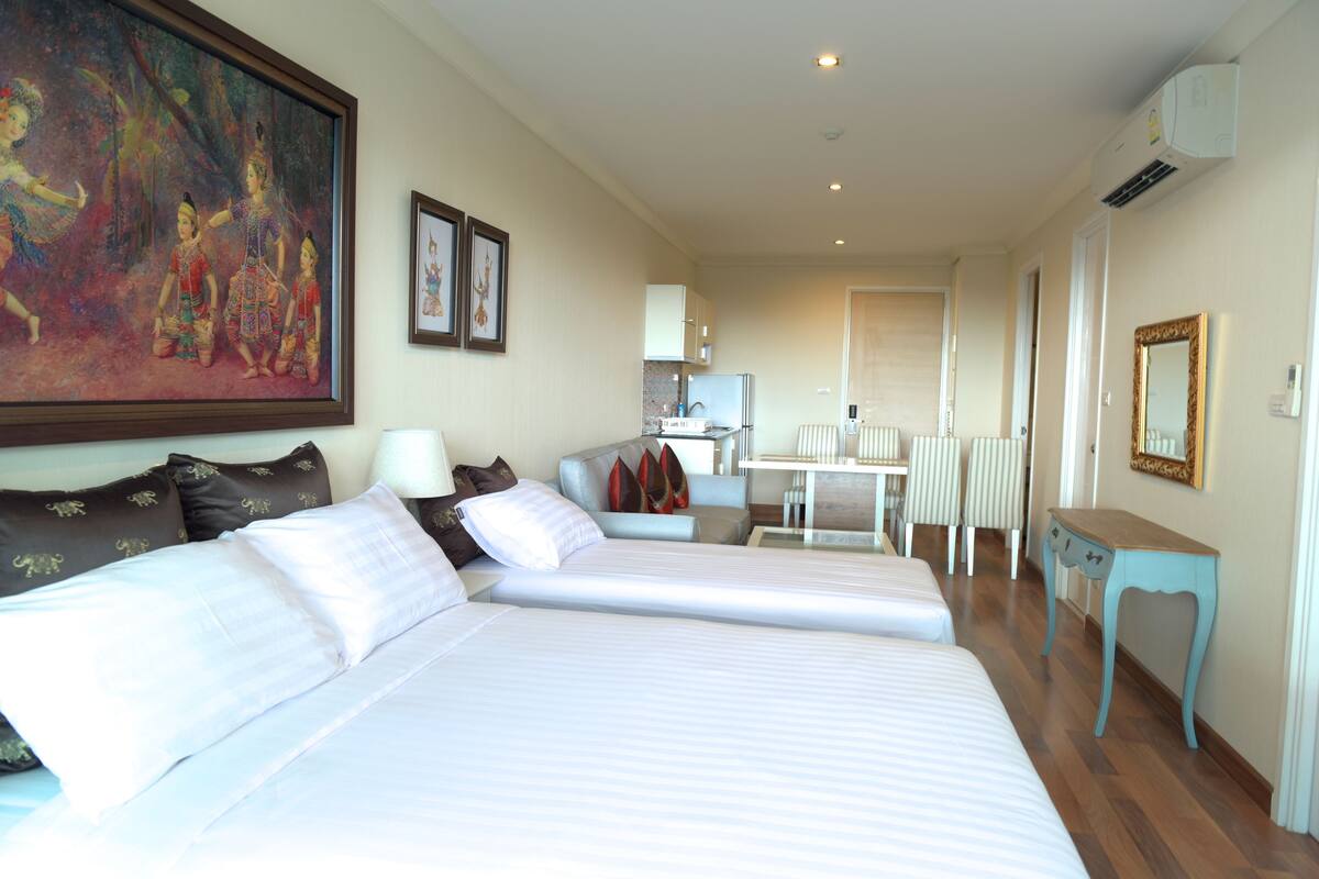 Une chambre d’hôtel avec deux lits, un coin repas et une cuisine.