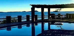 A wooden deck with a clear view of the water and distant islands. - Lake Safari Lodge (Siavonga)