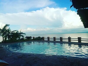 A swimming pool with a view of the sea and mountains in the background. - Lake Safari Lodge (Siavonga)