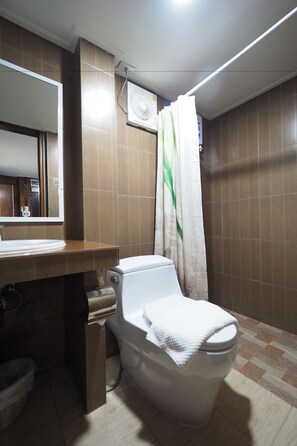 A bathroom with a toilet, sink, and mirror. - Khaung Chang Kam Boutique Hotel (Nan)