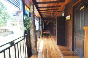 A wooden hallway with a wooden floor, a balcony with a railing, and a door labeled "101". - Khaung Chang Kam Boutique Hotel (Nan)