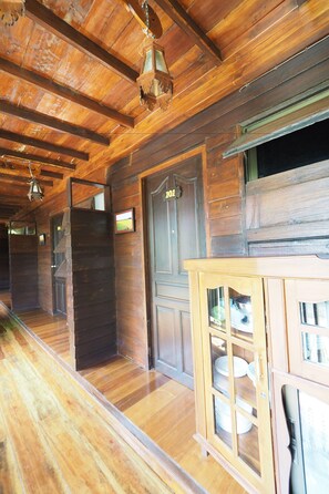 A wooden interior with a wooden door marked "101", a wooden cabinet with glass doors, and a wooden staircase. - Khaung Chang Kam Boutique Hotel (Nan)
