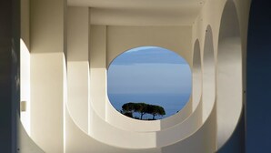 A circular architectural feature with a view of trees and a body of water. - Casa Colarusso (Massa Lubrense)