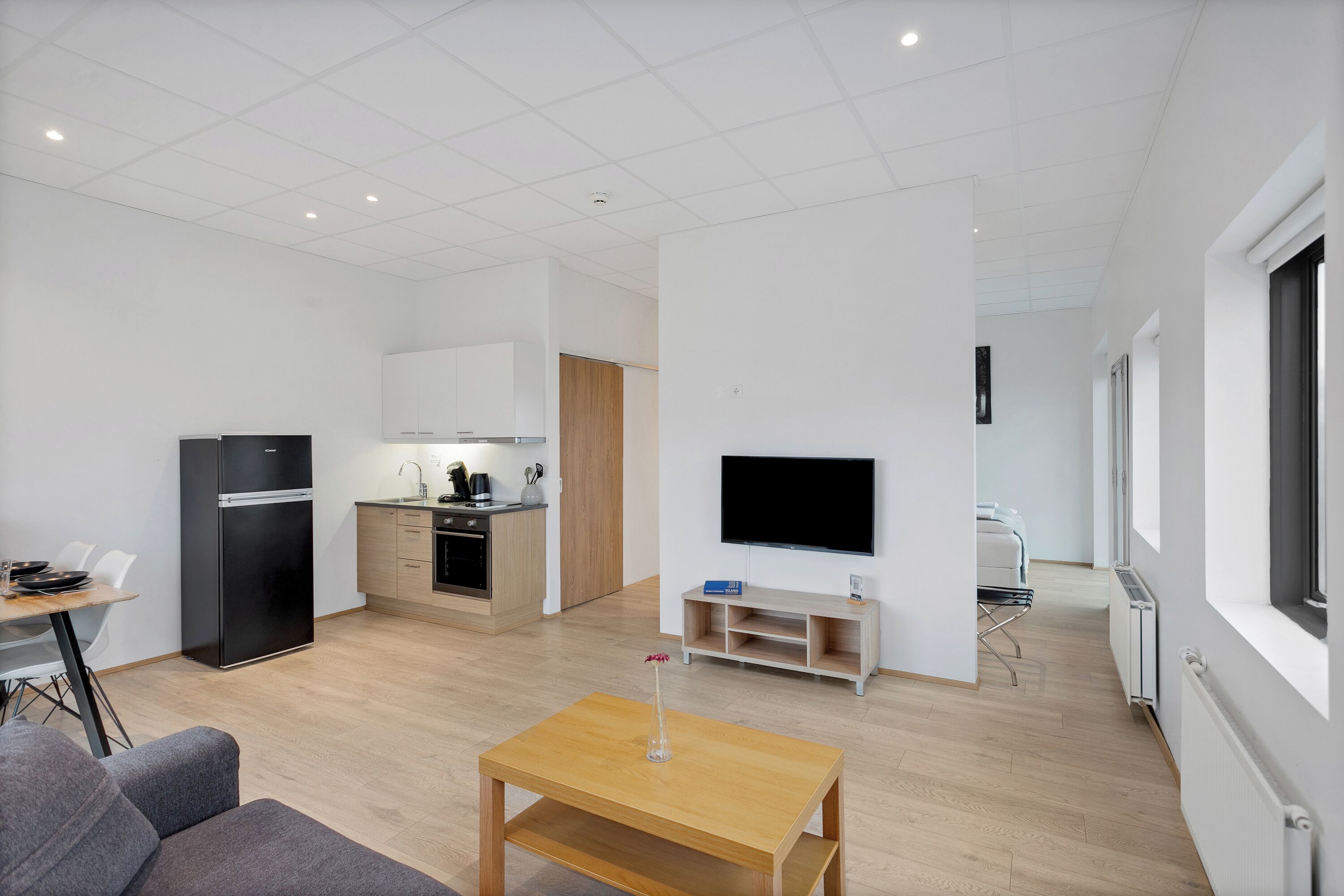 A modern apartment with a kitchen, dining area, and living room.