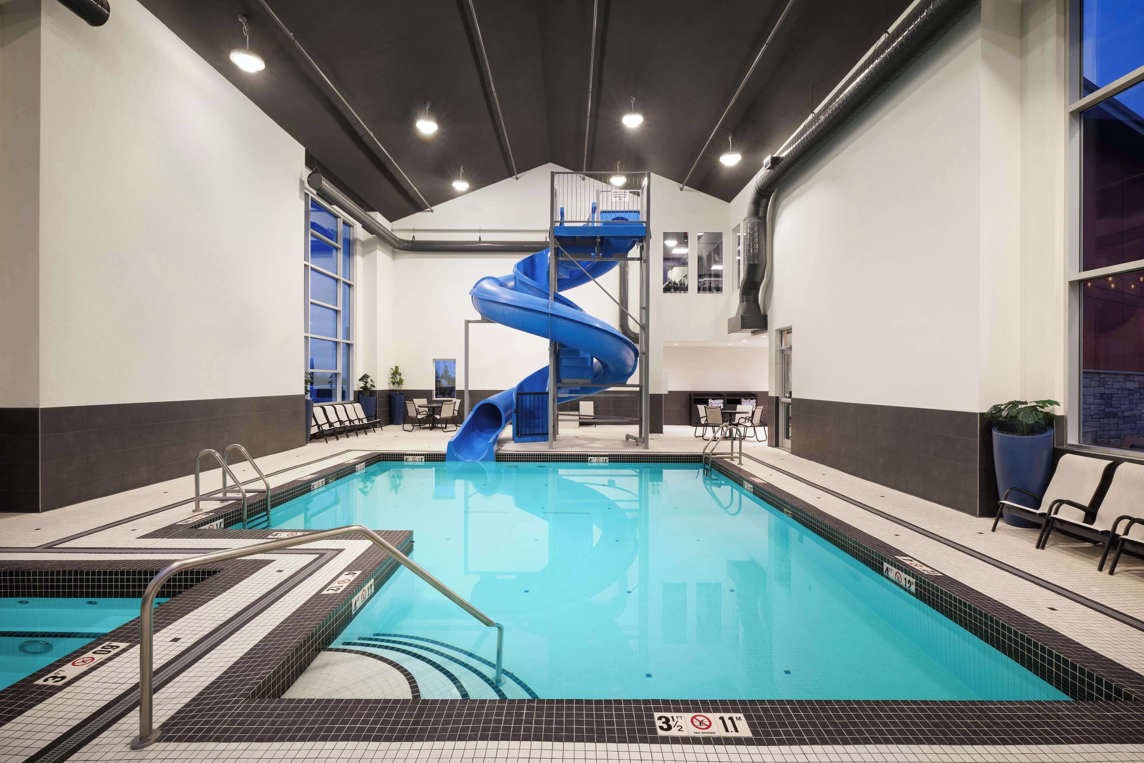 Una piscina techada, sillones reclinables de piscina