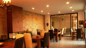 Un comedor con paredes de ladrillo, mesas y sillas de madera.