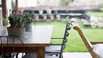 A wooden table with potted plants and a metal chair.