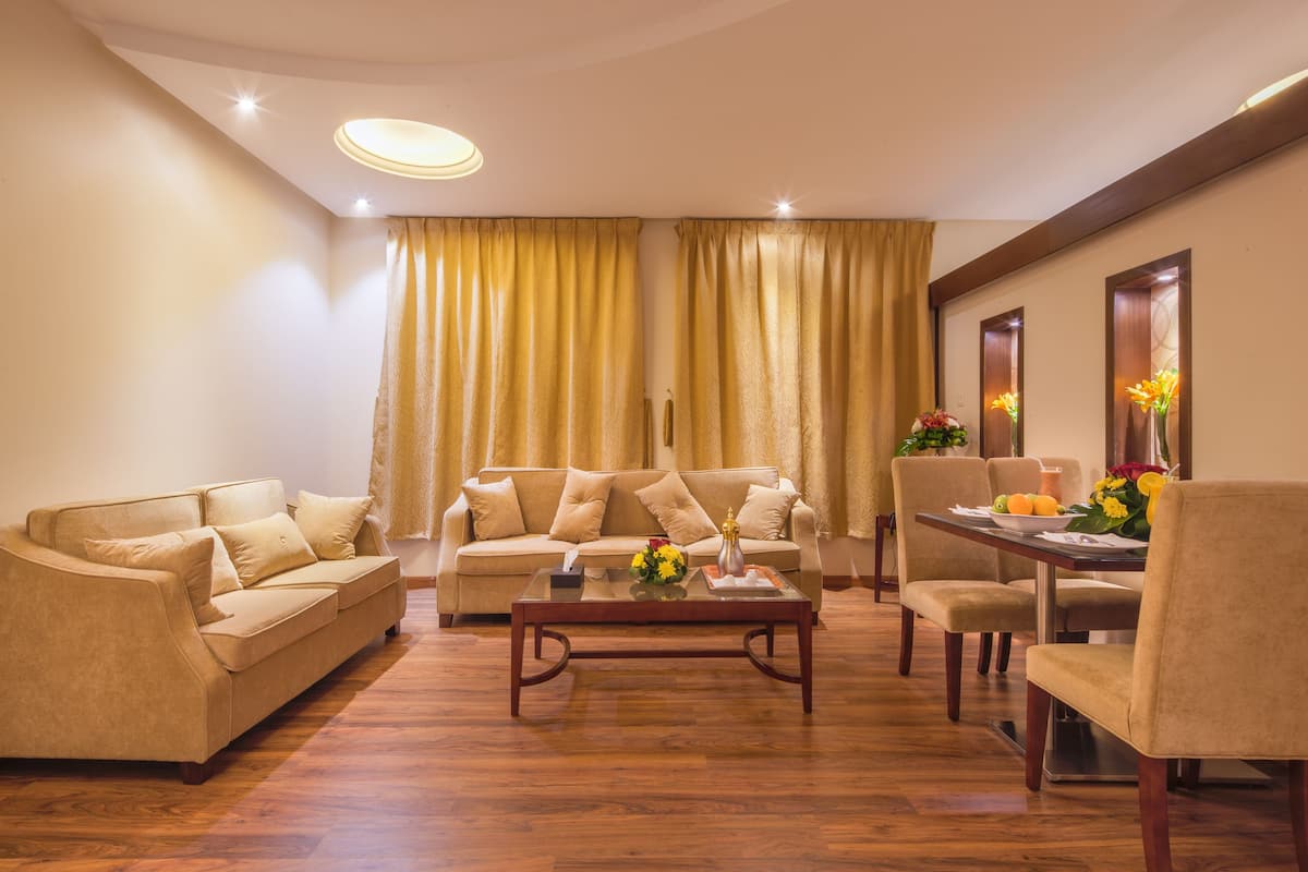 A living room with a sofa, coffee table, and dining table with chairs.