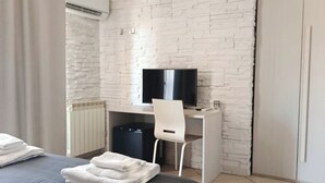 A bedroom with a bed, a desk with a chair, a television, and a wardrobe. - Central Park B&B (Casarile)