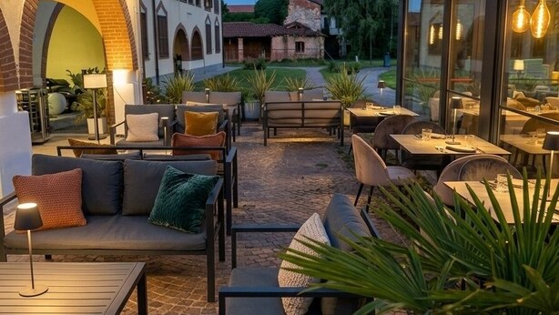An outdoor patio area with seating arrangements, tables, and potted plants. - Central Park B&B (Casarile)