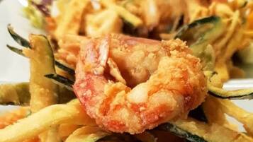 Un piatto di frittura mista con gamberi e verdure.
