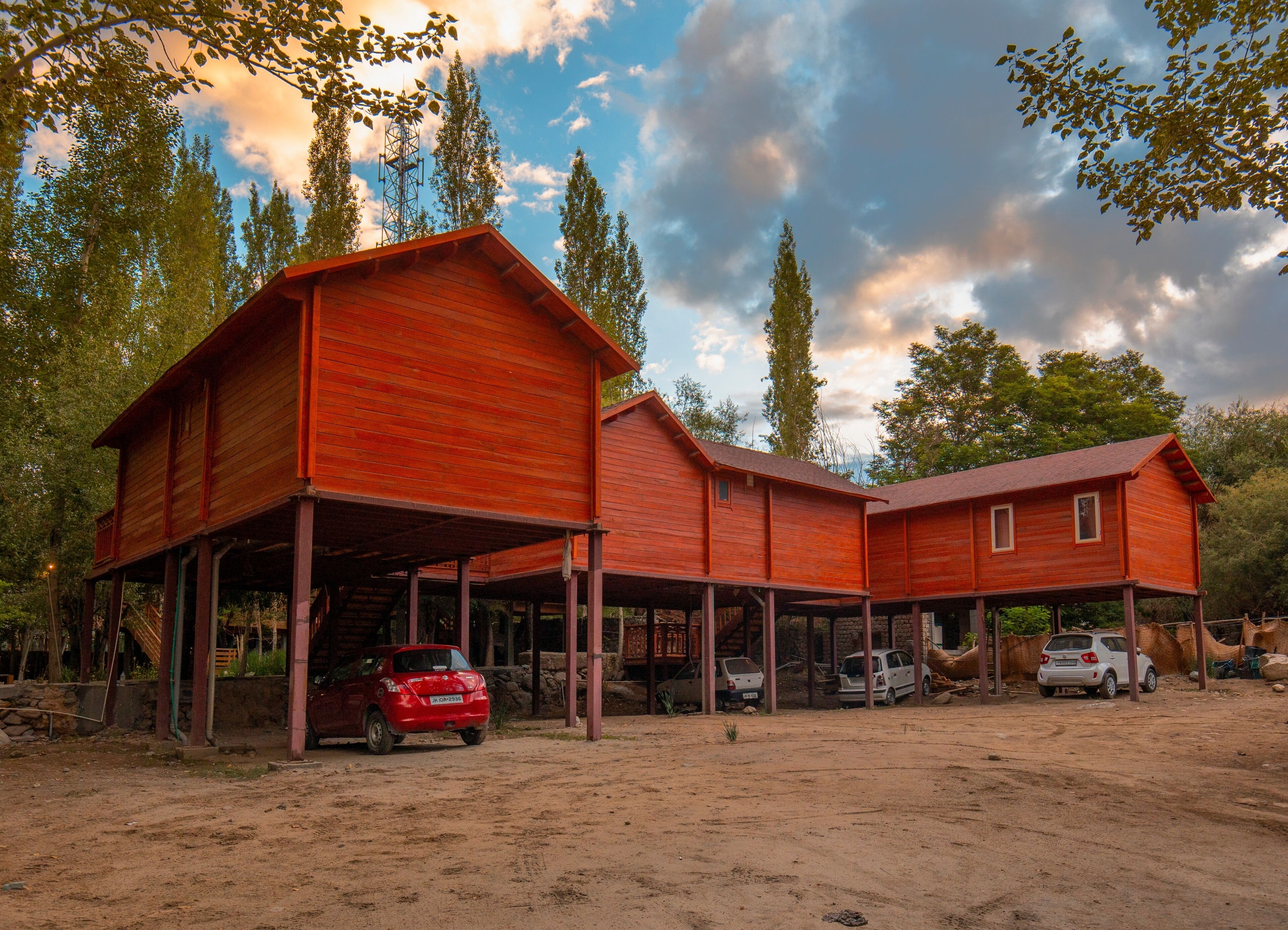 A wooden building with a covered porch and multiple cars parked in front.