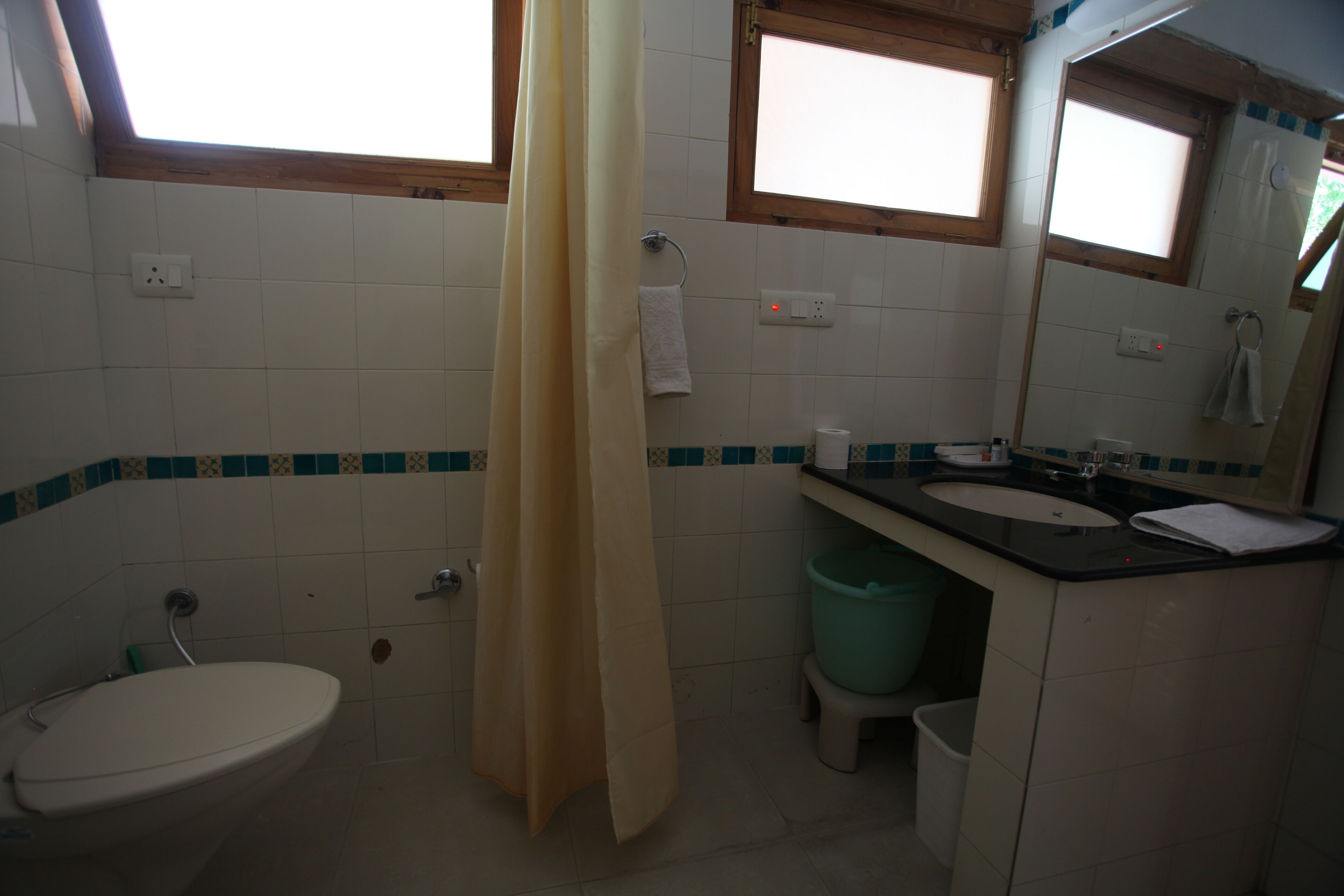A bathroom with a toilet, sink, and shower curtain.