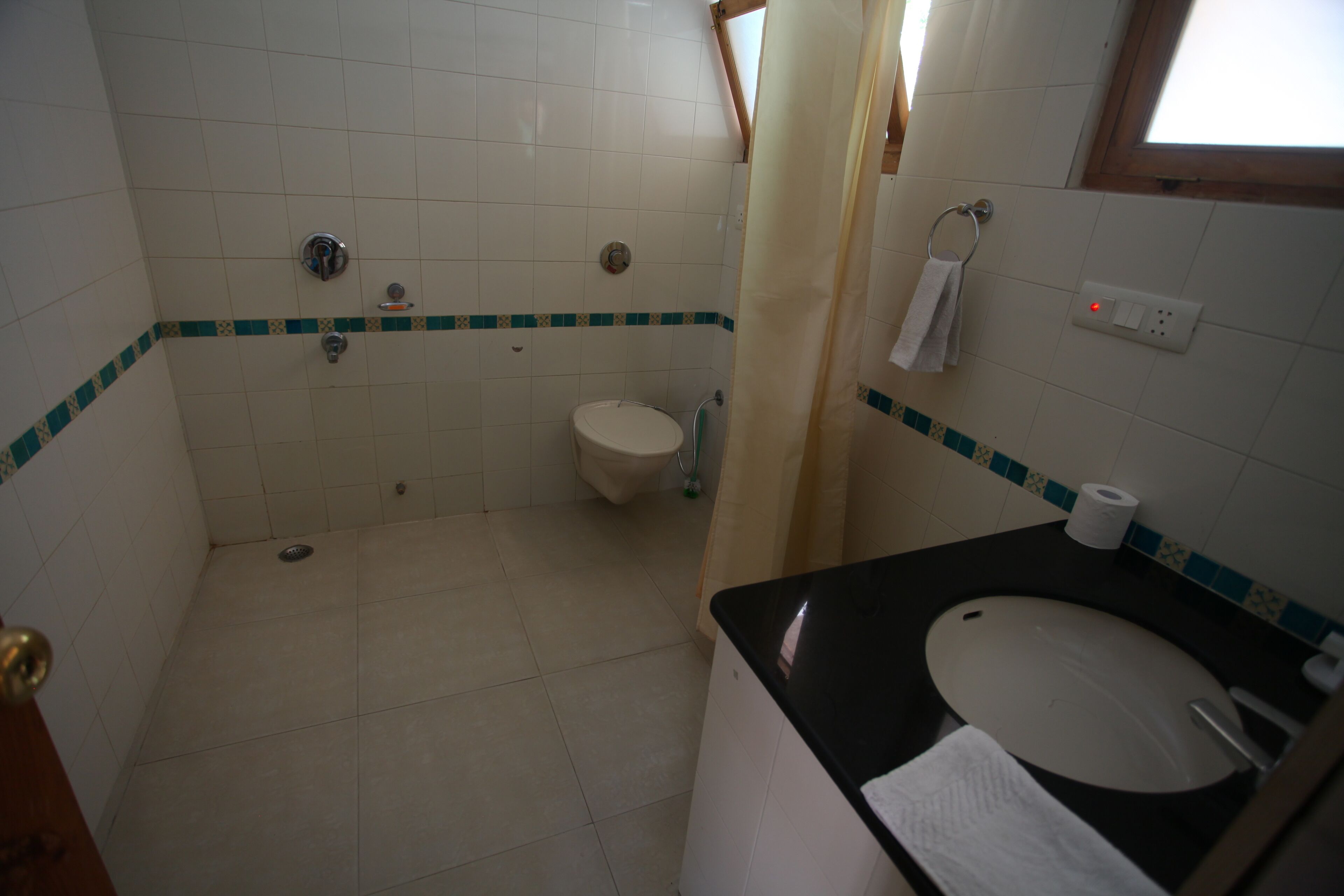 A bathroom with a toilet, sink, and shower.