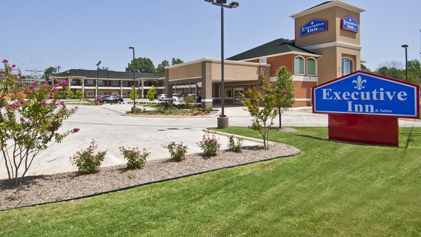 A hotel with a prominent sign reading "Executive Inn & Suites."