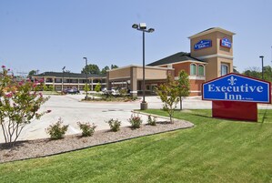 Un hotel con un letrero llamativo que dice "Executive Inn & Suites".