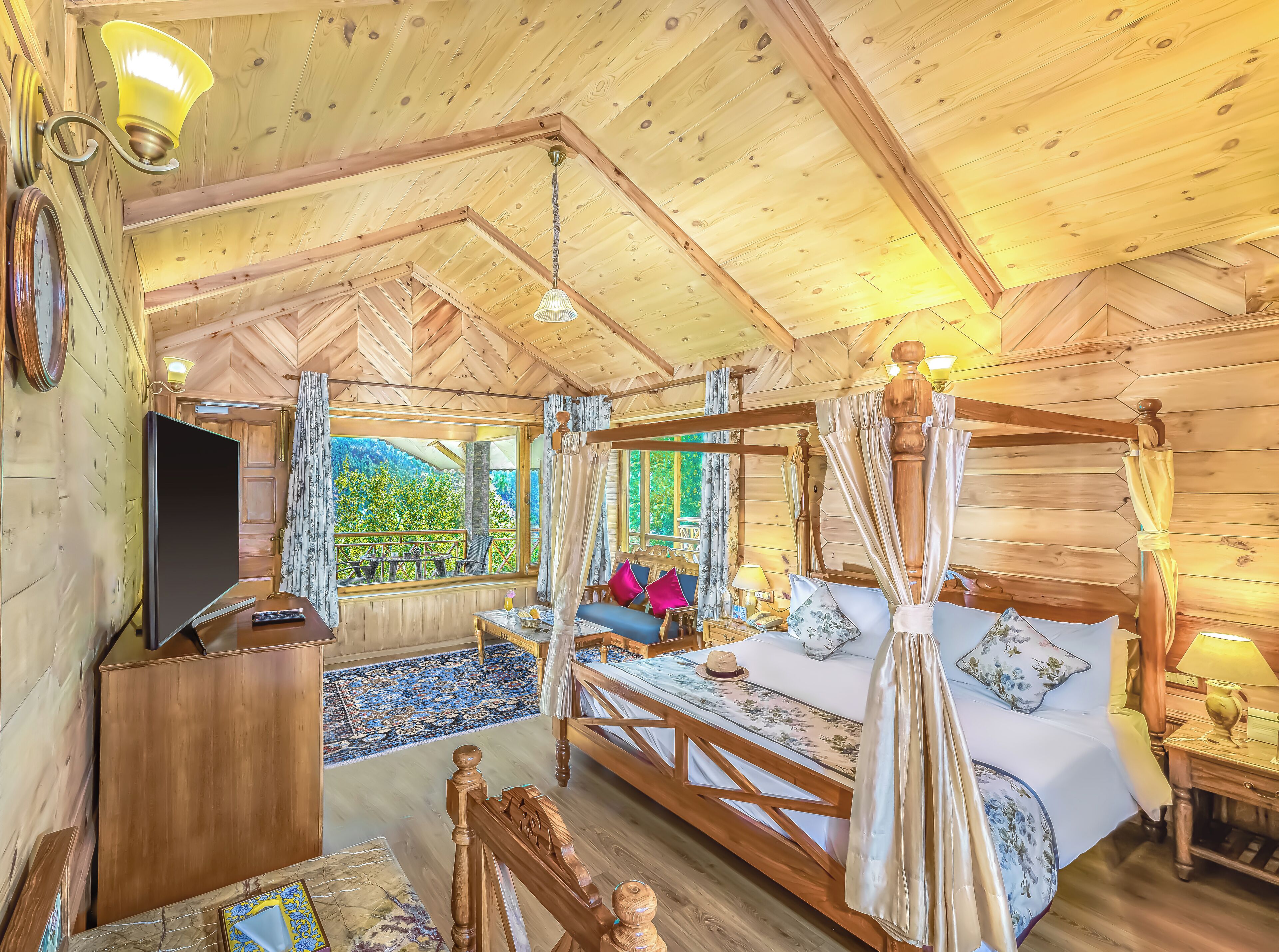 Habitación de cabaña de madera con una cama, un televisor y vistas al verdor exterior.