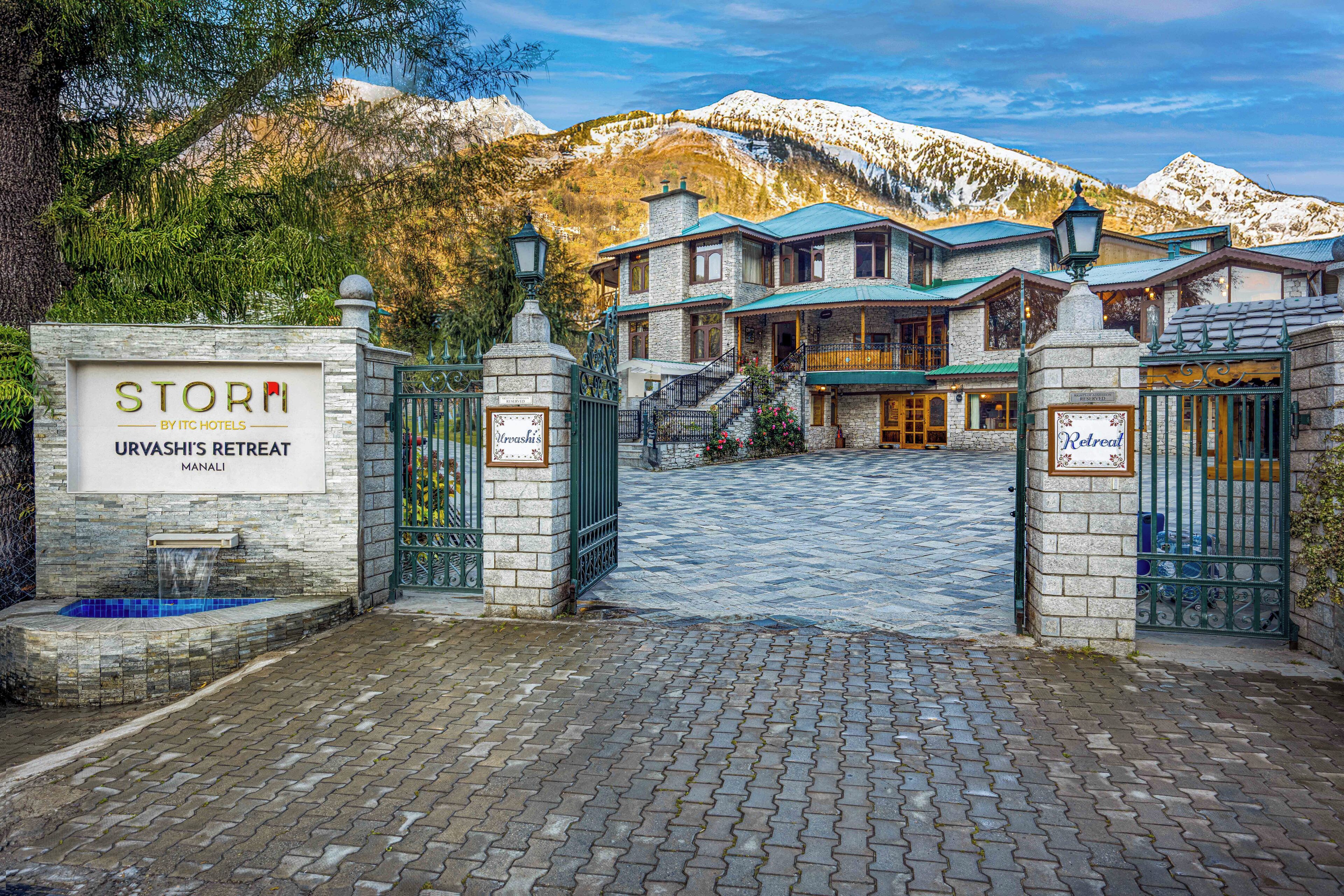 A stone gate with a sign for 'STORM URVASHI'S RETREAT MANALI'.