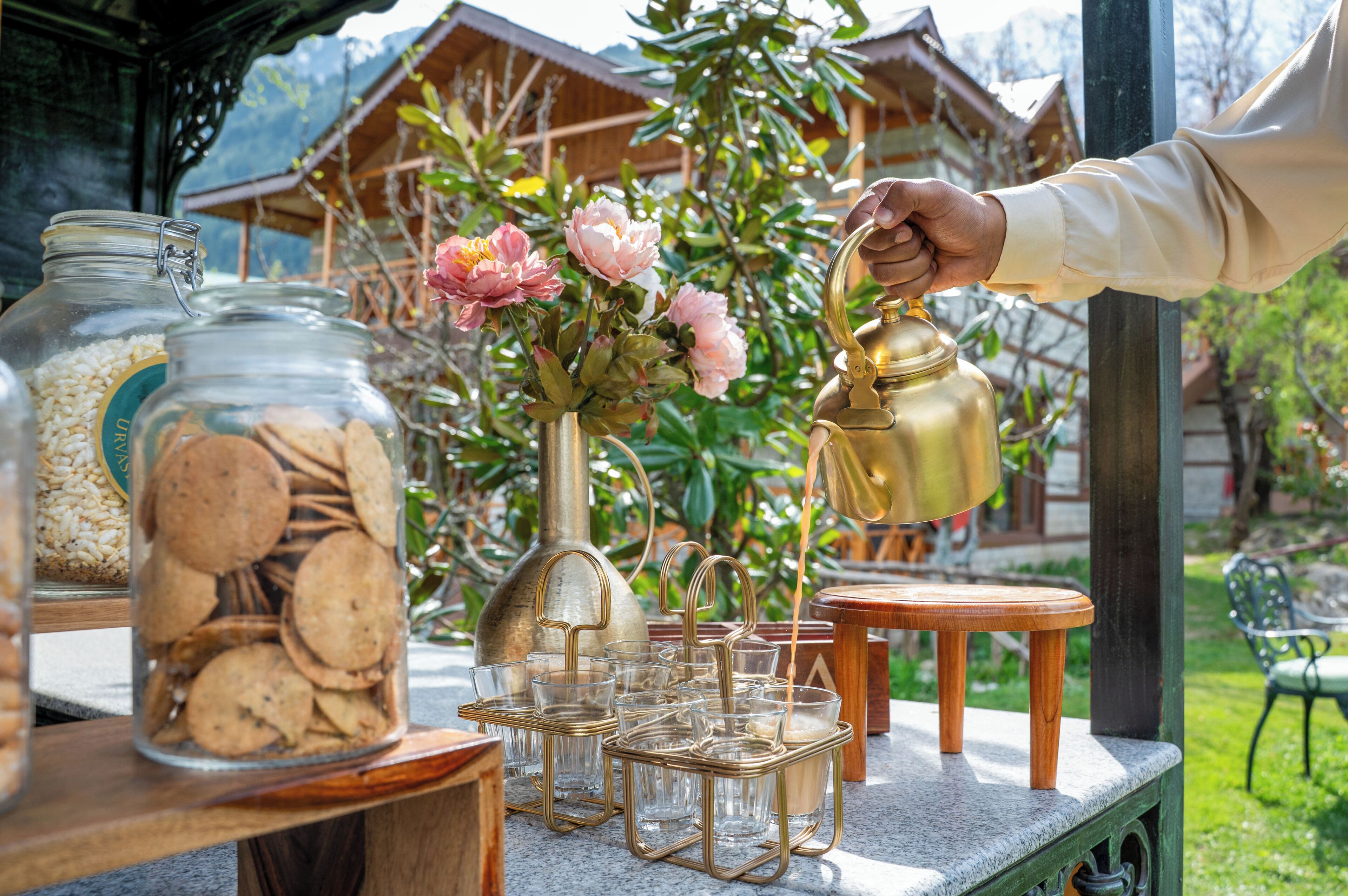 A table with jars of cookies and a tea set.